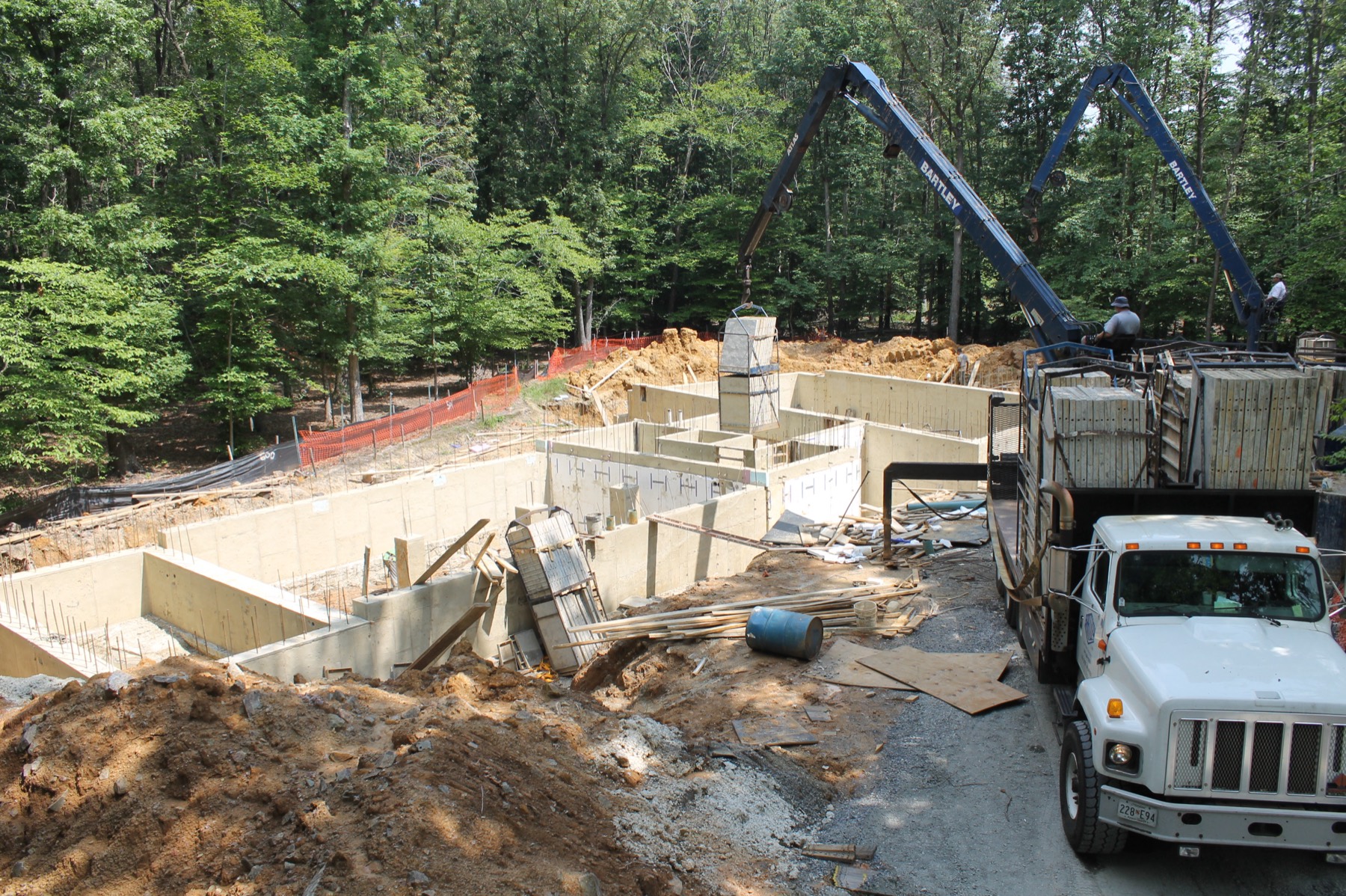 Poured foundation walls with a boom truck lifting formwork